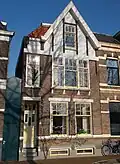 Woning, onderdeel van een statige pleinwand