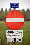 Een oud bord en onderbord die aangeven dat de weg gesloten is in één richting voor al het verkeer behalve voetgangers, maar dat fietsers en bromfiets zijn uitgesloten van dit verbod, in Breda.