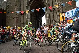 Het peloton rijdt onder de Utrechtse Domtoren door.