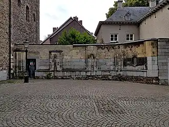 Restant van de kapel: de noordmuur. In het plaveisel de contouren van andere muren en steunberen