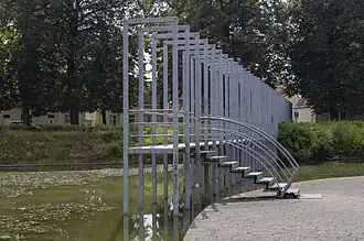 Brug van eiland in vijver Kromhoutpark naar de Ruysdaelstraat.