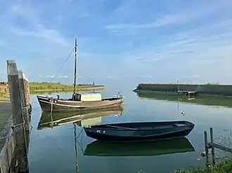 Het haventje met een roeiboot en een oude vissersschuit