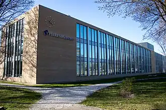 De bijzondere klok en het logo van het Theresialyceum aan de oostgevel van de school.