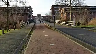 Johan Neeskensbrug met op de achtergrond bebouwing aan de Middenweg en links de Muurschildering Johan Cruijff (januari 2020)