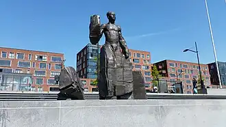 Monument voor Anton de Kom (mei 2020) Op de achtergrond Bijlmerdreef
