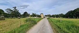 De Castertweg ten westen van Hoeve Caestert. De weg doorsnijdt de archeologische vindplaats. De fotograaf staat nabij de noordwestelijke poort