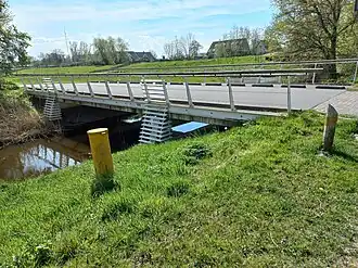 Brug 1572 in Baron Schimmelpenninck van der Oyeweg met op achtergrond bebouwing Osdorperweg (april 2022)