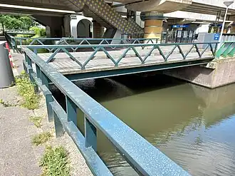 Brug 729 met op de achtergrond Station Lelylaan; brugnummerplaat rechts (juni 2022)