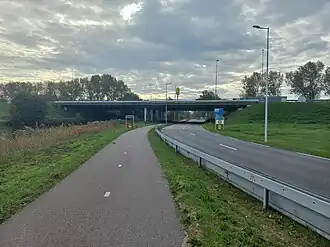 De IJdoornlaanbrug gezien vanuit het noorden. Links water Nieuwe Gouw, midden IJdoornlaan, boven Rijksweg 10 met daarachter embleem McDonald (oktober 2022)