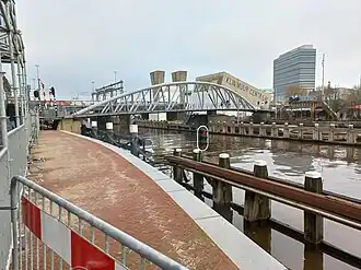 Zijaanzicht van de brug vanaf het Oosterdokseiland met links een hellingbaan (januari 2023)