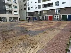 Medewerkers van Kunstwacht Delft (beheerder van buitenkunst in Amsterdam) reinigen Complex form Koeriersterplein (augustus 2023)