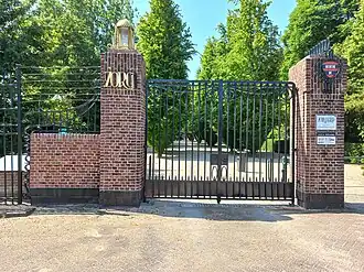 Toegangspoort richting aula (mei 2023) Rechtsboven wapen van Nieuwer-Amstel