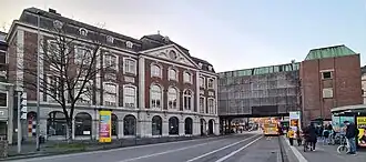 Façade aan de Kurhausstraße met afgesloten arcade en moderne aanbouw Klangbrücke (2025)