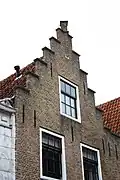 Logegebouw: huis met gecementeerde trapgevel. De treden afgedekt met natuurstenen platen. Waterlijst