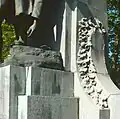 Loof van eikenblaadjes, uit arduin gehouwen, op het monument te Sint-Niklaas.