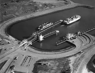 Uitvarend de veerboot 'Marsdiep'. Gemeerd langs de zij-aanlegsteiger de 'Dageraad' en langs het lange fuikeiland de 'Koningin Wilhelmina'.