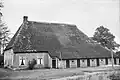 Forse boerderij Steenbergen[1] onder rieten schilddak; in de voorgevel schuifvensters met roedenverdeling. Schuurtje van hout onder rieten schilddak