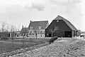 Boerderij, bestaande uit een dwars woonhuis onder zadeldak en rechts daarnaast een grote gepotdekselde stal onder rieten wolfdak. Het woonhuis heeft rechts een opkamer, vensters met zesruitsschuiframen en luiken en links een zomerhuis onder zadeldak
