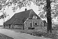 Boerderij onder met riet gedekt schilddak. Onderschoer. Voorgevel met een 12-ruitskozijn met luiken behangen. Twee kleine ramen. Gesloten deur met bovenlicht. Pui met haalboom