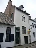 Huis met smalle lijstgevel, met ingang in Naamse steen.