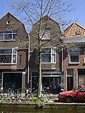 Bedrijfspand met bovenwoning, in 1928 naar ontwerp van J. Th. Van Rossum voor G.C. Kunz gebouwd in een traditionalistische stijl met invloeden van de Amsterdamse School.