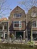 Bedrijfspand met bovenwoning, in 1928 naar ontwerp van J. Th. Van Rossum voor J.A.J. van Leeuwen gebouwd, in een traditionalistische stijl met invloeden van de Amsterdamse School.