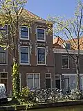 Pand, in oorsprong bedrijfspand met bovenwoning, in 1902 gebouwd volgens ontwerp van C.J.L. Kersbergen, in traditionalistische stijl met invloeden van de Nieuwe Kunst.