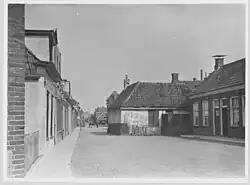 Excentrisch gebouw aan de Achterweg (later hernoemd tot Merwedestraat) in 1930. Het gebouw werd aangekocht door de gemeente om het te slopen om de weg te kunnen verbeteren. Gezien naar het noorden. De rooilijn werd ter plaatse een stuk naar achteren verplaatst. Het huis bevond zich ter hoogte van Merwedestraat 34, dat een jaar later werd gebouwd in 1931.