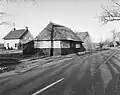Bij het leegstaande boerderijtje Rheezerweg 95 langs de weg een schuurtje met wanden van stro en hout onder rieten schilddak