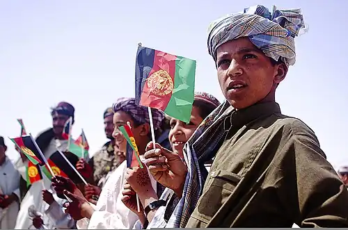 Afghaanse kinderen zwaaien met nationale vlaggen in de provincie Helmand