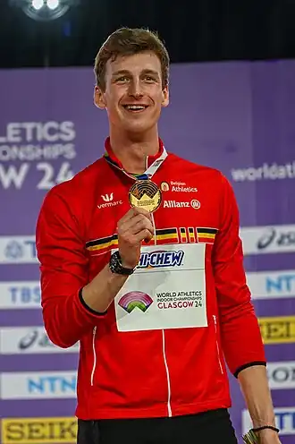 Alexander Doom toont zijn gouden medaille van de 400 m tijdens de WK indoor van 2024 in Glasgow.