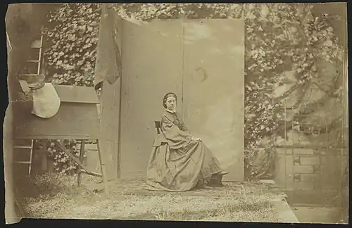 Alexine Tinne zittend voor een kamerscherm in de tuin van Lange Voorhout 32 te Den Haag; geheel links haar rijzadel. Foto door Alexine Tinne en assistent, juli 1860.