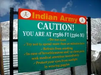 Waarschuwingsbord met advies: niet inspannen, na 20 minuten terugkeren, niet roken, draag een zonnebril en zoek onmiddellijk medische hulp bij ademnood of pijn op de borst