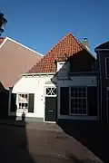 Gewit laag huis met rechte kroonlijst. Boerenhoeve type
