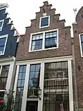 Huis met slechts een zolderverdieping boven de hoge hoofdverdieping; trapgevel op houten pui