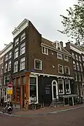 Hoekhuis aan de keizersgracht met voorgevel onder rechte lijst en op balkkoppen overgebouwde zijgevel