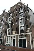 Dubbel pakhuis met trapeziumgevel, gevelsteen en vakwerkpui