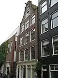 Huis met gevel onder klokvormige top met rollagen