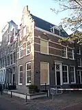 Hoekhuis met trapgevel en zijgevel, versierd in de trant met de grote boogblokken