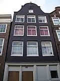Huis met gevel onder klokvormige top met rollagen