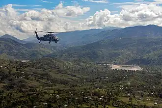 Een Amerikaanse helikopter is met hulpgoederen onderweg naar het dorp Jabouin na de doortocht van orkaan Matthew in Haïti, waar zo'n 1000 slachtoffers waren gevallen.