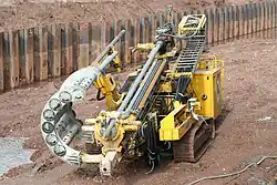 Boormachine met stangenmagazijn voor het plaatsen van groutankers