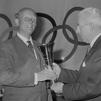 Dokkum (links) krijgt in 1965 als voorzitter van de Roeibond de Van Tuyllbeker uitgereikt door NOC-voorzitter Herman Adriaan van Karnebeek.