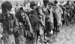 Oorspronkelijk onderschrift: "Kinderen wachten in de sneeuw voor toegang tot de 'Weesstad', een dagelijks spektakel van 's morgens vroeg tot 's avonds laat" (The Story of Near East Relief, 1930).