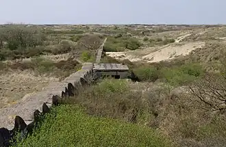Berkheide. Relict van de Atlantikwall, anti-tankmuur, haaks op de kustlijn