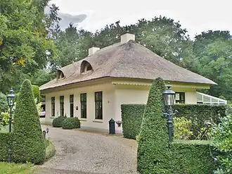 Hilversumsestraatweg 22, witgepleisterde dienstwoning met chinees overstekend rieten dak met houten kartellijst