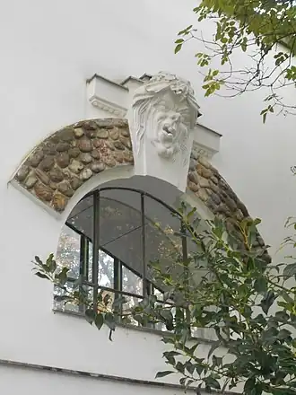 Bacchusmasker in de gevel boven de ramen van het trappenhuis aan de kanaalzijde.