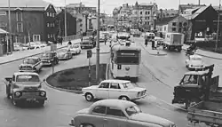 Tram te midden van het steeds drukker wordende autoverkeer; 1964.