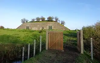 Zicht op de bovenste verdieping van de kazerne. Achter de grote schuifdeuren, geheel links en rechts, zijn de remises.