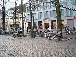 Bronzen beelden zittend op bankjes